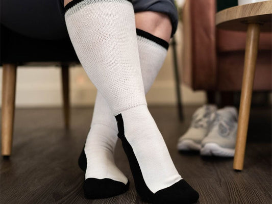 A person sitting on a chair wearing white diabetic socks
